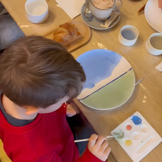 Enfant qui peint une assiette en céramique